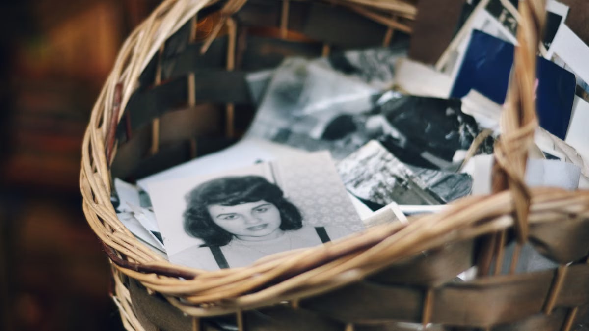 A collection of vintage black and white photos in a woven basket evokes nostalgia.